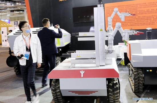 A visitor walks pass exhibits during the 8th China (Shanghai) International Technology Fair (CSITF) in east China's Shanghai, April 15, 2021. The 8th CSITF kicked off on Thursday. With an exhibition area covering 35,000 square meters, this year's fair has 5 different sections and has attracted over 1,000 exhibitors. (Xinhua/Fang Zhe)