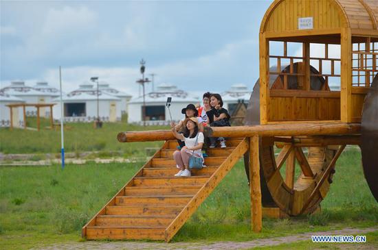 Aerial photo taken on Aug. 4, 2020 shows tourists visiting a scenic spot in Hulunbuir, north China's Inner Mongolia Autonomous Region. Local authorities in Hulunbuir have taken various measures, such as a more flexible working schedule and issuing tourist coupons, to boost local tourism market. (Xinhua/Xu Qin) 