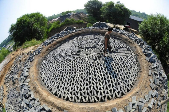 A worker carries cyan bricks on the top of a brick kiln of the Chu'an Town brick factory in Renqiu City, north China's Hebei Province, Sept. 28, 2021. (Xinhua/Mu Yu)