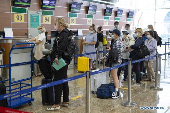 Passengers stand in line to check in at the Sheremetyevo International Airport in Moscow, Russia, on Aug. 1, 2020. Russia has partially resumed its international flights starting Aug. 1, according to reports. (Photo by Alexander Zemlianichenko Jr/Xinhua)