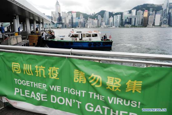 Photo taken on July 20, 2020 shows a banner with slogans on fighting COVID-19 in Tsim Sha Tsui, south China's Hong Kong. (Xinhua/Wang Shen)