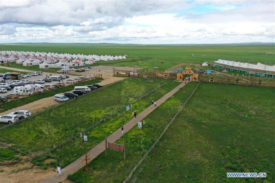 Aerial photo taken on Aug. 4, 2020 shows tourists visiting a scenic spot in Hulunbuir, north China's Inner Mongolia Autonomous Region. Local authorities in Hulunbuir have taken various measures, such as a more flexible working schedule and issuing tourist coupons, to boost local tourism market. (Xinhua/Xu Qin) 