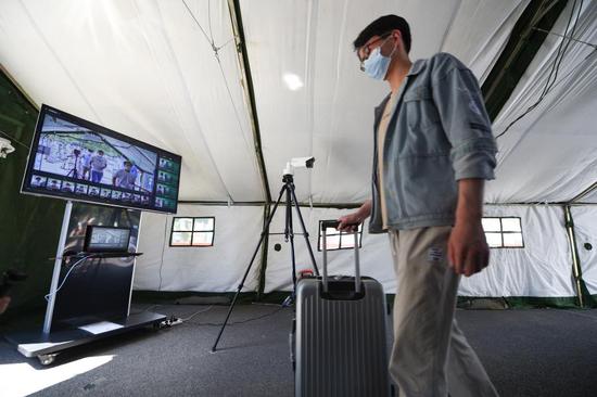 A man has his temperature checked during an epidemic prevention and control drill at Beijing University of Chemical Technology in Beijing, capital of China, May 27, 2020. (Xinhua/Ju Huanzong)