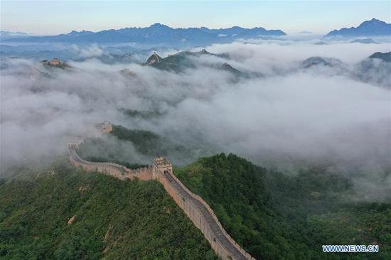 Aerial photo taken on Aug. 10, 2020 shows the Jinshanling Great Wall shrouded in morning mist in Luanping County of Chengde City, north China's Hebei Province. (Photo by Zhou Wanping/Xinhua)
