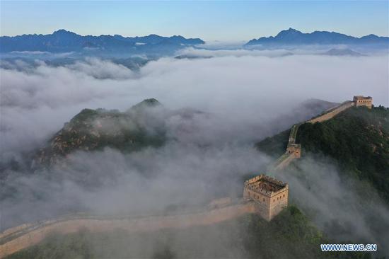 Aerial photo taken on Aug. 10, 2020 shows the Jinshanling Great Wall shrouded in morning mist in Luanping County of Chengde City, north China's Hebei Province. (Photo by Zhou Wanping/Xinhua)