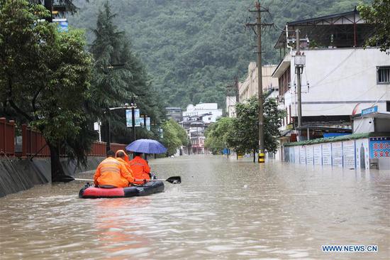 Trapped people are transferred by a bulldozer in Wudu District of Longnan City, northwest China's Gansu Province, Aug. 17, 2020. Week-long torrential rains in Gansu Province have led to a tributary of Yangtze River flowing above danger-level as local authorities battle various rain-triggered disasters including mountain torrents, landslides and mudflows. By Monday, rains damaged 3,303 km of roads in the city of Longnan, disrupting traffic on 497 roads. More than 38,000 people have been relocated in Longnan. (Xinhua/Chen Bin)