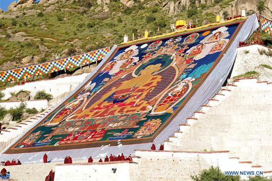 Photo taken on Aug. 19, 2020 shows a huge Thangka painting displayed during a traditional 