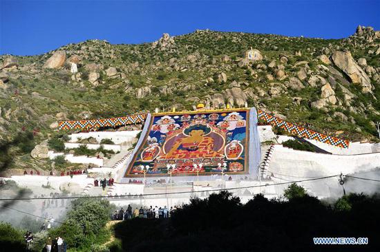 Photo taken on Aug. 19, 2020 shows a huge Thangka painting displayed during a traditional 