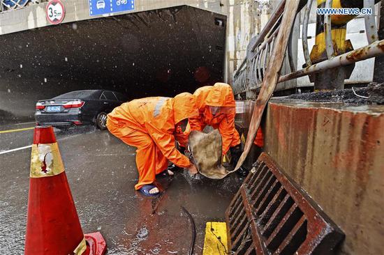 Workers install flood drainage equipment next to a road tunnel amid a downpour in Benxi, northeast China's Liaoning Province, Aug. 27, 2020. Typhoon Bavi, the eighth of this year, brought gales and rainstorms to cities in northeast China. (Photo by Lin Lin/Xinhua)