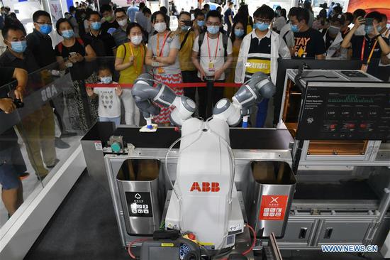 Visitors watch the demonstration of a waste sorting robot at the comprehensive exhibition area of the 2020 China International Fair for Trade in Services (CIFTIS) in Beijing, capital of China, Sept. 5, 2020. The 2020 CIFTIS is the first major international economic and trade event held both online and offline by China since the COVID-19 outbreak. A total of 18,000 enterprises and institutions from 148 countries and regions and about 100,000 people have registered for the fair. (Xinhua/Lu Peng)