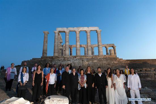 Chinese Ambassador to Greece Zhang Qiyue (6th R, Front) poses for a group photo with guests and musical performers in front of the ruins of the Temple of Poseidon at cape Sounion, some 70 km southeast of Athens, Greece, on Sept. 17, 2020. On the occasion of the 70th anniversary of the establishment of the Greek National Tourism Organization (GNTO) and the 71st anniversary of the founding of the People's Republic of China and the Mid-Autumn festival, a musical entitled "As long as there shall be Achaeans -- Variations on a Sunbeam" was staged on Thursday in front of the ruins of the emblematic 2,500-year-old Temple of Poseidon, the god of the sea in Greek mythology. (Xinhua/Marios Lolos)