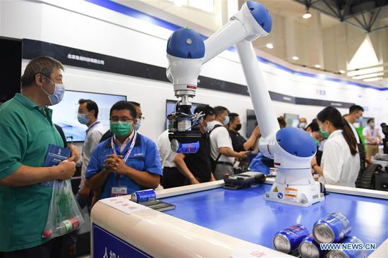 People watch a robot at the 23rd China Beijing International High-tech Expo in Beijing, capital of China, Sept. 17, 2020. The high-tech expo kicked off in Beijing on Thursday, showcasing the latest technological achievements. (Xinhua/Ju Huanzong)