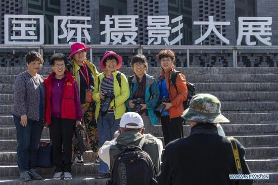 People pose for photos during their visit at the Pingyao International Photography Festival at Pingyao County in Jinzhong, north China's Shanxi Province, Sept. 19, 2020. The festival kicked off on Saturday, displaying more than 10,000 photography works by over 2,400 photographers from 15 countries and regions. (Xinhua/Yang Chenguang)