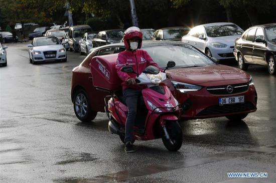 A delivery man wearing a face mask rides a motorcycle in Ankara, Turkey, on Sept. 20, 2020. The country's daily COVID-19 cases increased by 1,519 on Sunday, raising the total diagnosed patients to 302,867, the Turkish Health Ministry announced. (Photo by Mustafa Kaya/Xinhua)