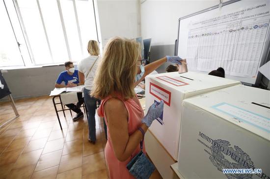 A woman casts her vote at a polling station in Naples, Italy, on Sept. 20, 2020. Over 46 million Italians are being called to the polls on Sunday and Monday in a nationwide constitutional referendum on cutting the number of lawmakers in the country's parliament. (Xinhua)