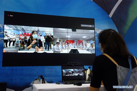 A visitor talks with researchers in China's Zhongshan Station in Antarctica via video during the 2020 East Asia Marine Expo in Qingdao, east China's Shandong Province, Sept. 22, 2020. The 2020 East Asia Marine Expo opened Tuesday in Qingdao, a coastal city of east China's Shandong Province, convening more than 770 companies and institutes from over 70 countries and regions. More than 50,000 different exhibits ranging from ocean engineering, offshore oil and gas exploration, seabed exploration, deep-sea aquaculture and scientific research equipment, to scientific achievements in marine surveying and mapping as well as fishery products have been put on show at the six-day expo, which boasts 60,000 square meters of exhibition area. (Xinhua/Li Ziheng)