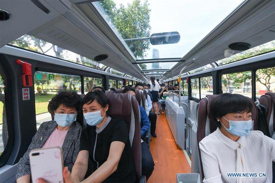 People take a sightseeing bus in Shenzhen, south China's Guangdong Province, Oct. 22, 2020. Shenzhen on Thursday launched three sightseeing bus lines for tourists, which respectively showcase the culture, technology and night view of the city. (Xinhua/Mao Siqian)