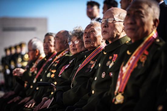 Chinese People's Volunteers (CPV) veterans and comrades pay tribute to martyrs of the CPV during a flower baskets presenting ceremony at the memorial tower in the Memorial Hall of the War to Resist U.S. Aggression and Aid Korea in Dandong, northeast China's Liaoning Province, on Oct. 23, 2020. (Xinhua/Pan Yulong)