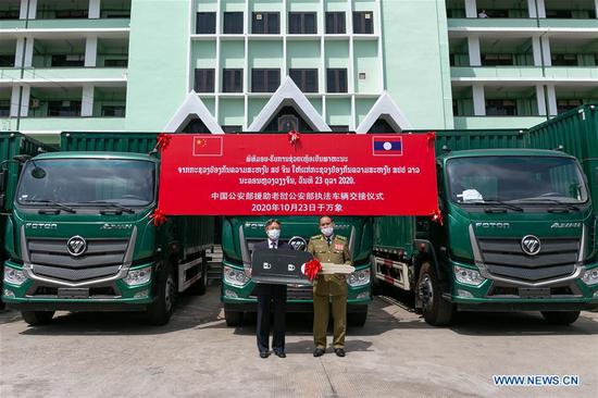 Chinese Ambassador to Laos Jiang Zaidong (L) and Vilay Lakhamfong, member of the Secretariat of the Lao People's Revolutionary Party Central Committee and Minister of Public Security, pose for a photo at the handover ceremony in Vientiane, Laos, Oct. 23, 2020. The Lao Ministry of Public Security has received the law enforcement vehicles in assistance provided by its Chinese counterpart. (Photo by Kaikeo Saiyasane/Xinhua)