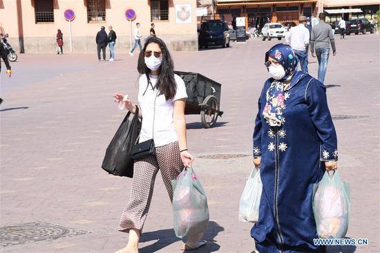 People wearing face masks are seen in a square in Marrakech, Morocco, on Oct. 25, 2020. In Morocco, the tally of COVID-19 cases rose to 197,481 after 3,020 new cases were added on Sunday, which included 3,301 fatalities and 163,195 recoveries. (Photo by Chadi/Xinhua)