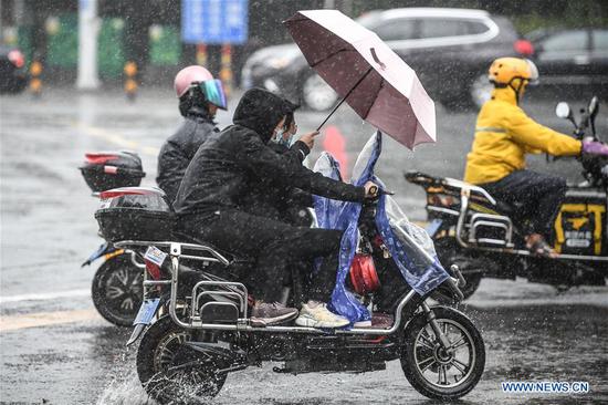 Cyclists ride in the rain in Haikou, south China's Hainan Province, Oct. 28, 2020. Molave weakened from a super typhoon to typhoon on Wednesday morning, bringing rainstorms to the island province of Hainan in south China, the local weather bureau said. (Xinhua/Pu Xiaoxu)