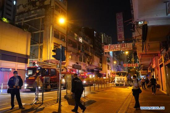 Fire fighters and police officers investigate a fire scene in Hong Kong, south China, Nov. 15, 2020. Seven people were killed and more than 10 others were injured after a fire broke out at a tenement building in Hong Kong on Sunday night, the police said. The fire, which occurred around 8 p.m. local time at the building along the Canton Road, Jordan, was extinguished about two hours later. (Xinhua/Lui Siu Wai)