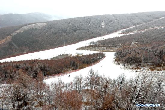 People ski at a ski field during a snowfall in Chongli District of Zhangjiakou City, north China's Hebei Province, Nov. 18, 2020. A snowfall hit Chongli on Wednesday. (Photo by Wu Diansen/Xinhua)