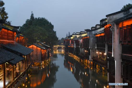 Tourists take a boat while visiting Wuzhen in east China's Zhejiang Province, Nov. 22, 2020. The World Internet Conference will be held here from Nov. 23 to 24, with the theme of 