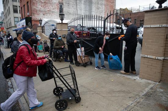 People line up outside a food pantry in Brooklyn, New York, United States, on Nov. 12, 2020. (Photo by Michael Nagle/Xinhua)