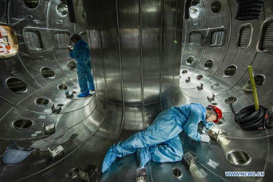 File photo taken on May 27, 2019 shows staff members of China National Nuclear Corporation (CNNC) Southwestern Institute of Physics working in the vacuum chamber of the HL-2M Tokamak, China's new-generation 