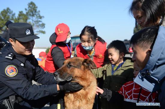 Citizens play with a police dog in Changsha, central China&#39;s Hunan Province, Jan. 9, 2021. A Police Camp Open Day event was held here to greet the first Chinese people&#39;s police day which falls on Jan. 10, 2021. (Xinhua/Chen Zhenhai)