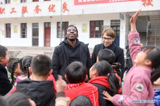 Albert Mhangami (1st L, back) of Zimbabwe, a master's degree student in the School of Social Sciences at Tsinghua University, plays with students at Dawancun Primary School in Lu'an City, east China's Anhui Province, Dec. 17, 2020. (Xinhua/Cao Li)