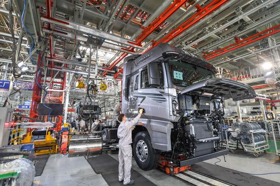 Workers assemble vehicles at the general assembly line of FAW Jiefang, a truck-manufacturing subsidiary of First Automotive Works (FAW) Group Co. Ltd., in Changchun, northeast China's Jilin Province, Sept. 23, 2020. (Xinhua/Zhang Nan)