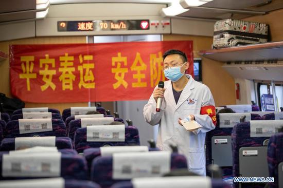 A police officer distributes epidemic prevention leaflets to passengers at Chongqingbei Railway Station in Chongqing, southwest China, Jan. 25, 2021. The prevention and control efforts against the COVID-19 epidemic are strengthened at railway stations in Chongqing to protect the safety of passengers. (Xinhua/Huang Wei)