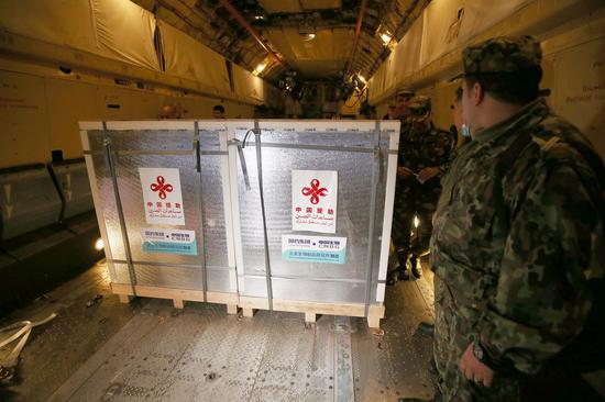 Photo taken on Feb. 24, 2021 shows staff members unloading COVID-19 vaccines at the military airport of Boufarik, 40 km southeast of the capital Algiers, Algeria. (Xinhua)