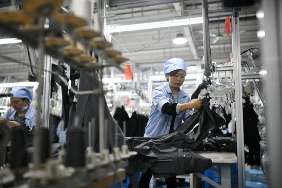 Female employees make garments in a poverty alleviation workshop in Tongxin County, northwest China's Ningxia Hui Autonomous Region, Feb. 24, 2021. (Xinhua/Wang Peng)