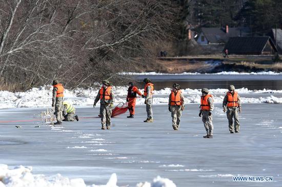 Members of Latvian armed forces prepare to blow up a huge ice congestion in the River Gauja near the central Latvian municipality of Carnikava, Latvia, on March 4, 2021. The Latvian armed forces on Thursday blew up a huge ice congestion in the River Gauja that had threatened to cause major floods in the area. (Photo by Edijs Palens/Xinhua)