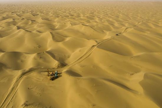Aerial photo shows workers of the geophysical survey team carrying out drilling work in the Taklimakan Desert, northwest China's Xinjiang Uygur Autonomous Region, Feb. 24, 2021. (Xinhua/Hu Huhu)