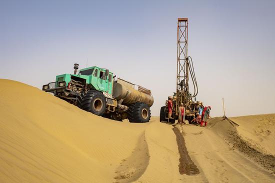 Workers of the geophysical survey team carry out the drilling work in the Taklimakan Desert, northwest China's Xinjiang Uygur Autonomous Region, Feb. 25, 2021. (Xinhua/Hu Huhu)