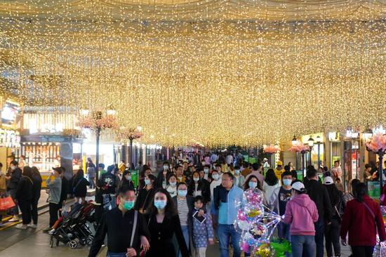 People visit a commercial street in Wuhan, central China's Hubei Province, March 28, 2021. (Xinhua/Cheng Min)