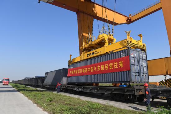 Workers hoist a container at the Nanning international railway port in Nanning, south China's Guangxi Zhuang Autonomous Region, Nov. 11, 2020. (Xinhua/Lu Boan)