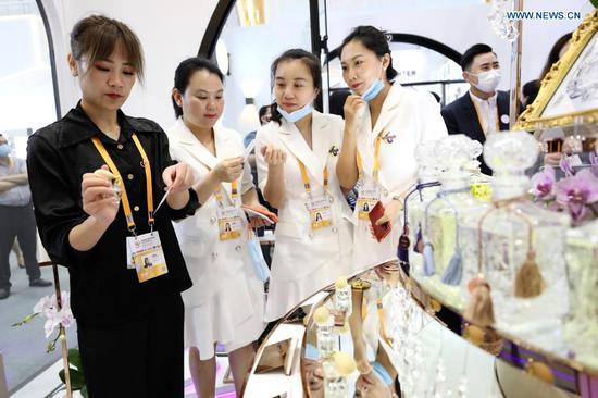 A visitor tries perfume in the Fashion Life Exhibition Hall of the first China International Consumer Products Expo in Haikou, capital of south China's Hainan Province, May 7, 2021. Slated for May 7-10, the first China International Consumer Products Expo has attracted 648 overseas companies and 1,365 brands from 69 countries and regions, as well as 857 enterprises and 1,263 brands from China. Covering 80,000 square meters, the expo will be the largest consumer goods expo in the Asia-Pacific region, the organizers said. (Xinhua/Jin Liwang)