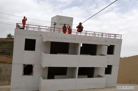 Armed police take part in a rope rescue training at the National Urban Search and Rescue (USAR) Training Center of Lanzhou in Yuzhong County of Lanzhou, capital of northwest China's Gansu Province, May 10, 2021. The National USAR Training Center of Lanzhou has a rescue team made up of armed police, medical staff and members of the China Earthquake Administration. The center, which has multi-functional professional training fields, facilities and equipment, can train professional rescue teams to deal with complicated circumstances. Meanwhile, as a state-level popular science education base for earthquake prevention and disaster reduction, it has opened various forms of popular science education classes. (Xinhua/Fan Peishen)