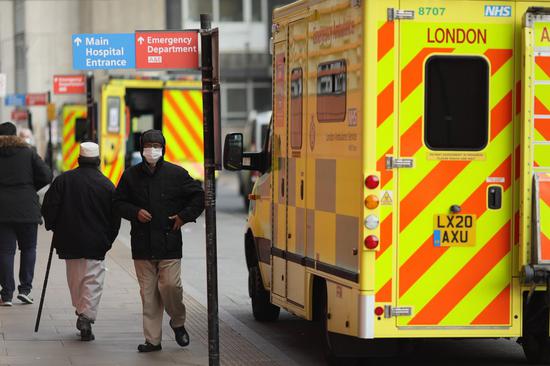 People walk past ambulances at the Royal London Hospital in London, Britain, on April 9, 2021. (Photo by Tim Ireland/Xinhua)