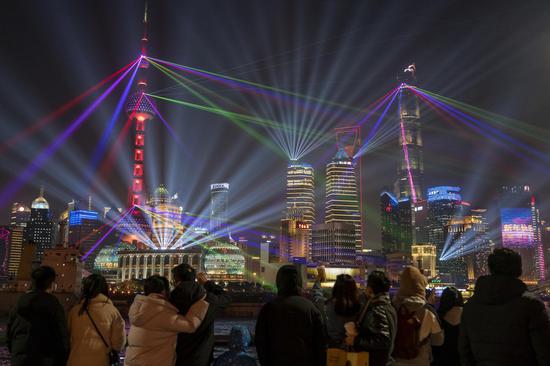 People enjoy the light show at the Bund in east China's Shanghai, Jan. 2, 2021. (Xinhua/Wang Xiang)