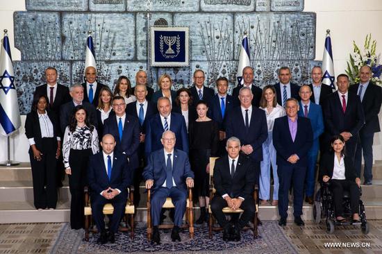 The new Israeli Prime Minister Naftali Bennett (L, front row), Israeli President Reuven Rivlin (C, front row) and Alternate Prime Minister and Foreign Minister Yair Lapid (R, front row) pose for a group photo with the new government ministers at the President's residence in Jerusalem, June 14, 2021. (JINI via Xinhua)