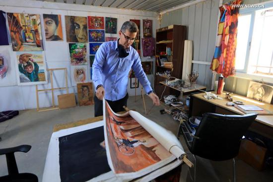 Mohamed Jokhadar shows his artworks in an interview with Xinhua at the Zaatari refugee camp, Jordan, June 17, 2021. Mohamed Jokhadar, a 35-year-old Syrian artist who lives in Jordan's Zaatari Camp for Refugees, uses his painting skills not only to restore hope among Syrian refugees but also to educate and empower them to realize a better future. (Photo by Mohammad Abu Ghosh/Xinhua)