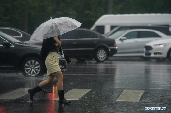 A citizen walks in rain near a subway station in Beijing, capital of China, July 12, 2021. Heavy rainstorm has lashed the Chinese capital Beijing since 6 p.m. Sunday with precipitation up to 116.4 mm, according to the municipal flood control department. From 6 p.m. Sunday to 9 a.m. Monday, Beijing registered average rainfall of 65.9 mm. Urban areas of the city reported higher average precipitation of 79.9 mm. (Xinhua/Peng Ziyang)