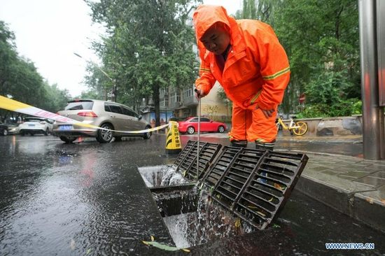 A worker checks the drainage system on a road in Chaoyang District of Beijing, capital of China, July 12, 2021. Heavy rainstorm has lashed the Chinese capital Beijing since 6 p.m. Sunday with precipitation up to 116.4 mm, according to the municipal flood control department. From 6 p.m. Sunday to 9 a.m. Monday, Beijing registered average rainfall of 65.9 mm. Urban areas of the city reported higher average precipitation of 79.9 mm. (Xinhua/Ju Huanzong)