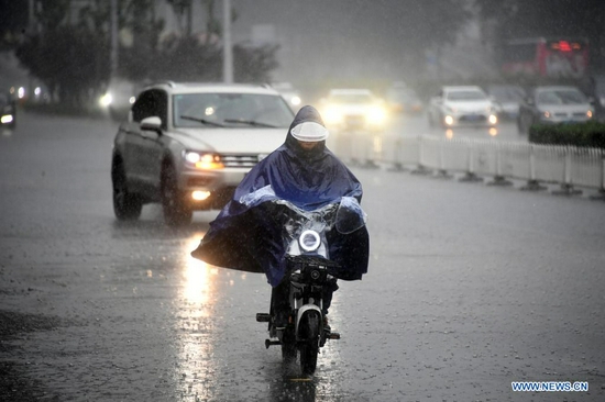 A citizen rides in rain on a street in Haidian District of Beijing, capital of China, July 12, 2021. Heavy rainstorm has lashed the Chinese capital Beijing since 6 p.m. Sunday with precipitation up to 116.4 mm, according to the municipal flood control department. From 6 p.m. Sunday to 9 a.m. Monday, Beijing registered average rainfall of 65.9 mm. Urban areas of the city reported higher average precipitation of 79.9 mm. (Xinhua/Ren Chao)